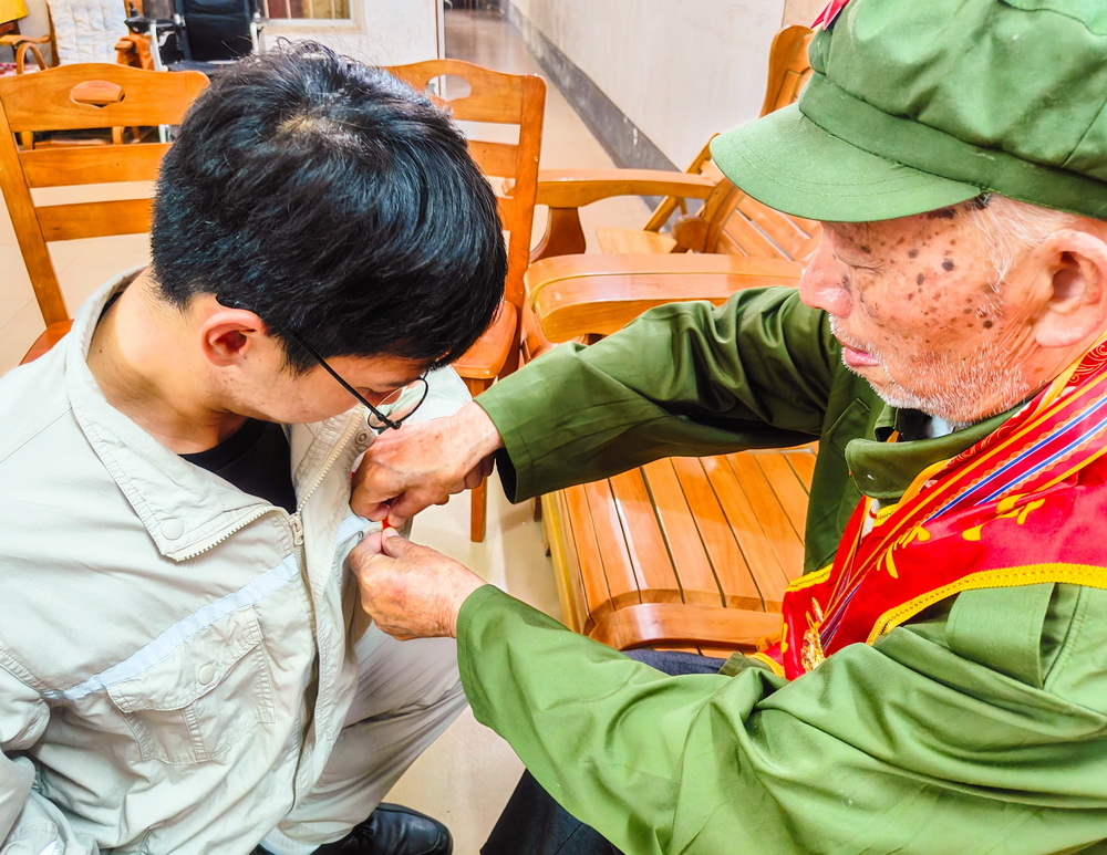 1688363847859062149.jpg 2、韦仕隆给新入党的青年党员佩戴党章--李阳摄.jpg